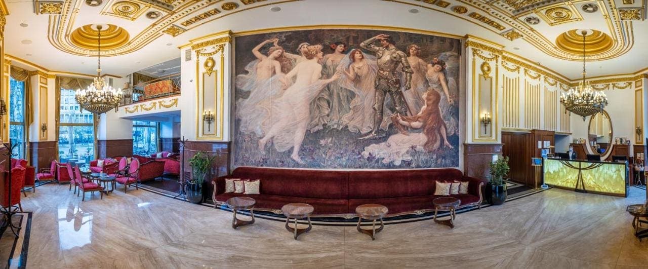 The lobby with a large painted mural above a red sofa