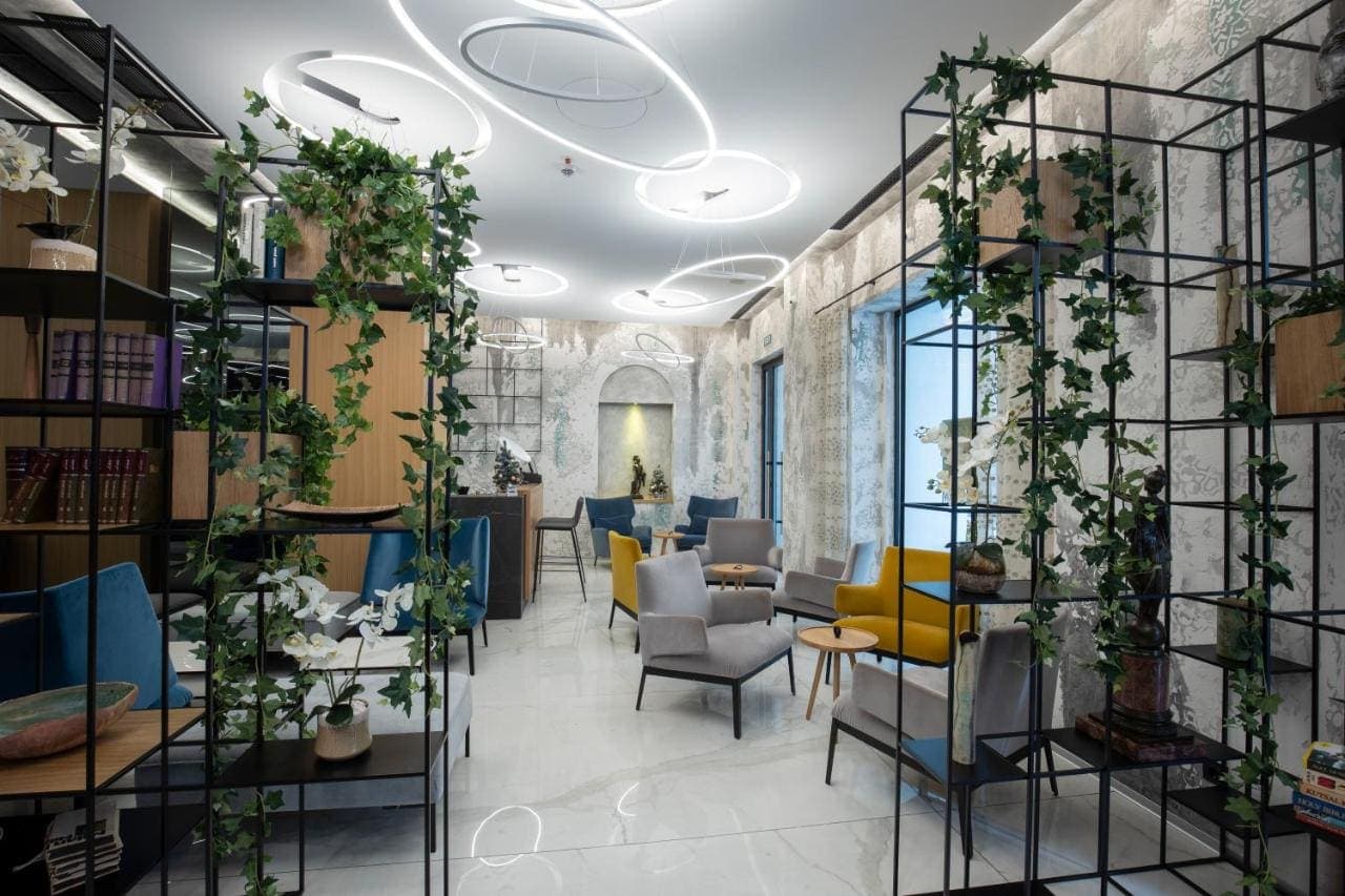 The lobby lounge with hanging plants and blue armchairs