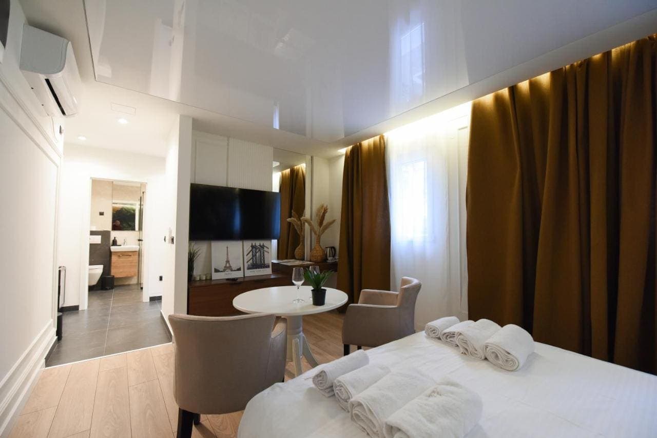 A bright room with a bed, a small round table, and armchairs