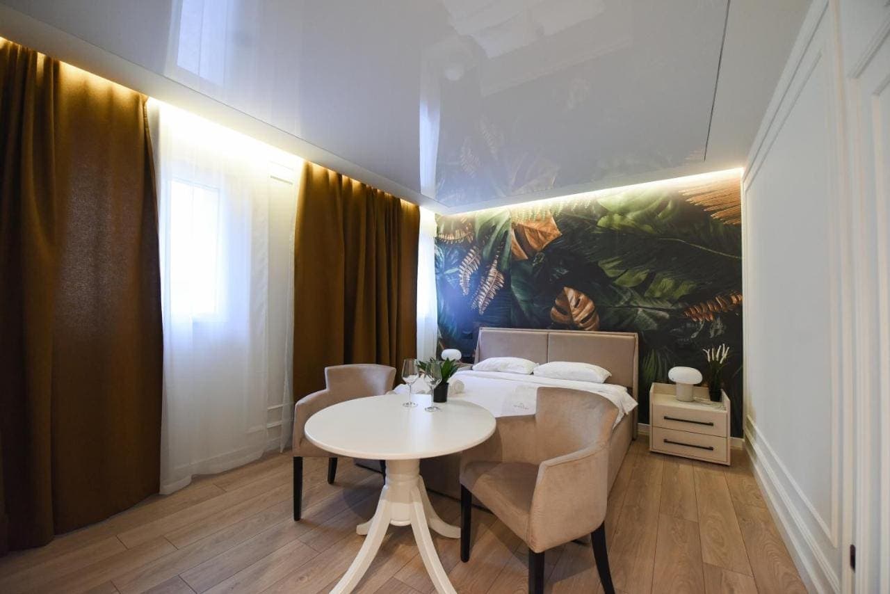 A room with a tropical leaf mural and a round table