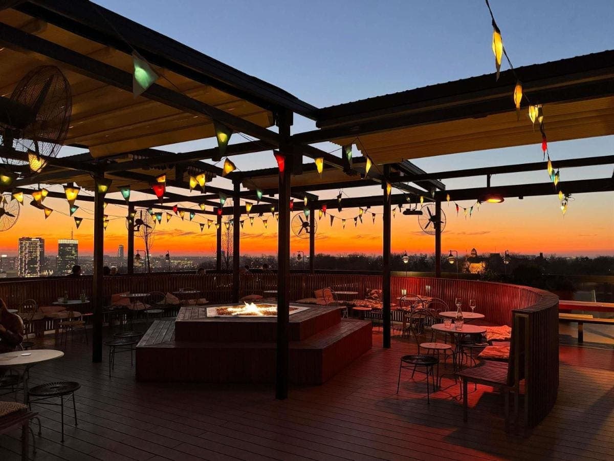 The Mama Shelter rooftop terrace at sunset, strung with flags and lights