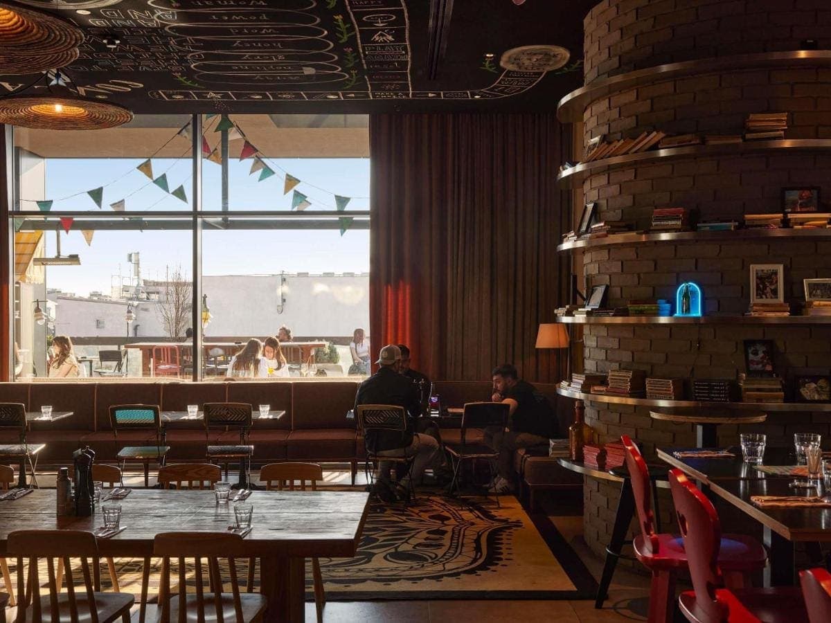 The restaurant with bookshelves and a window onto the rooftops
