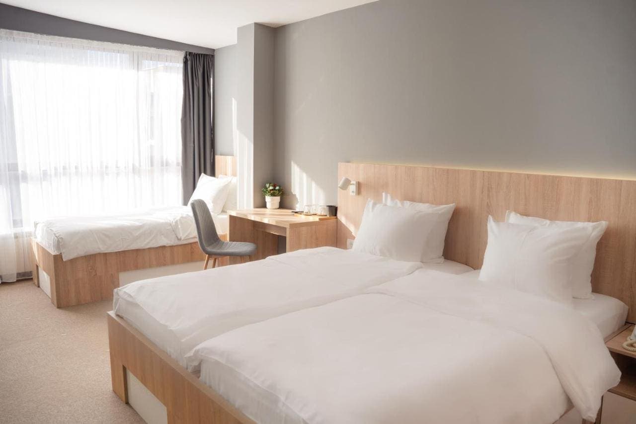 A bright twin room with light wood furniture