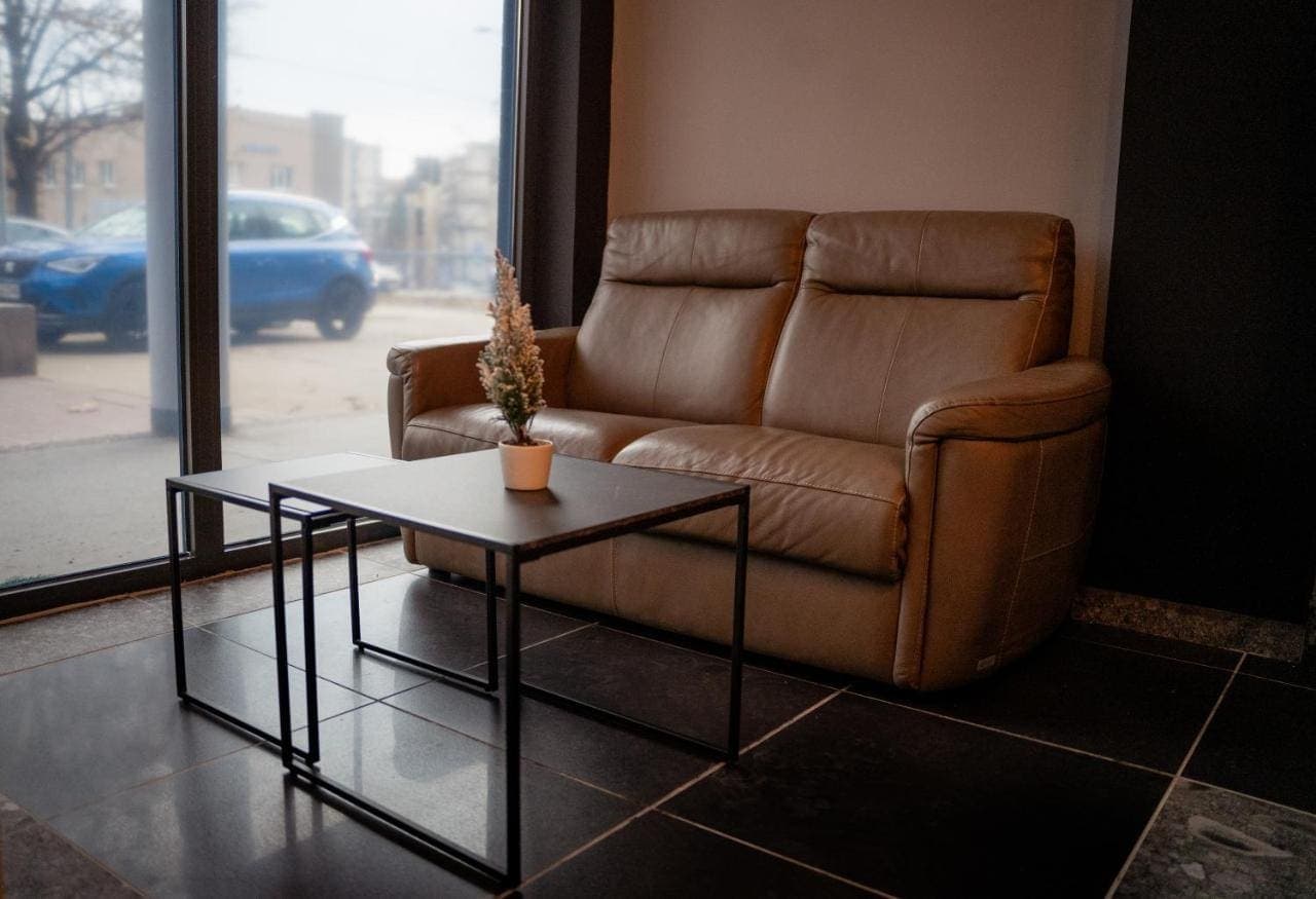 A lounge with a leather sofa by a floor-to-ceiling window