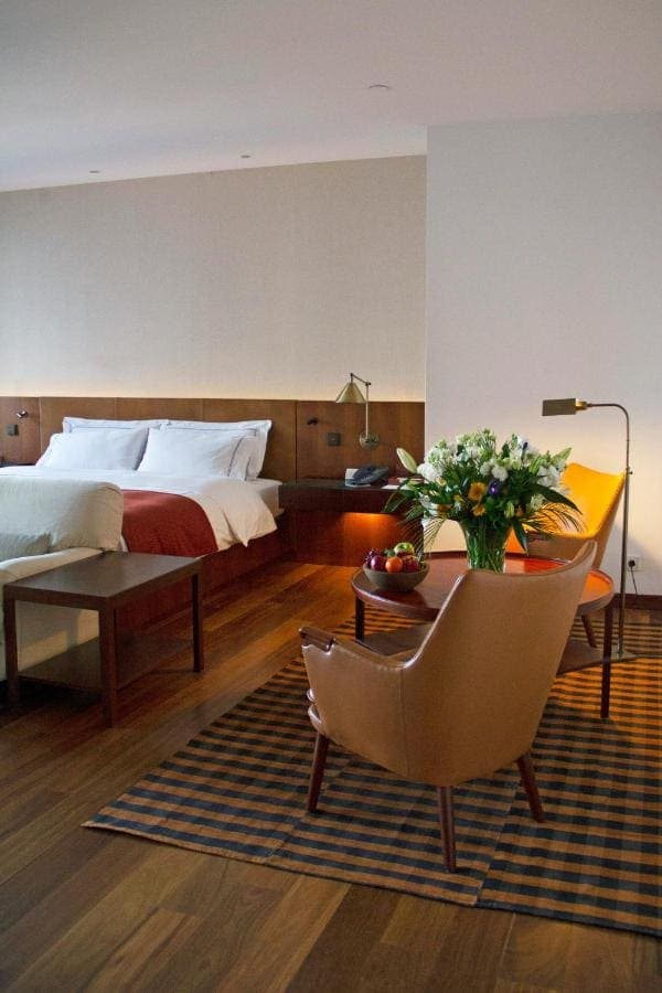 A deluxe room with wood panelling and an armchair