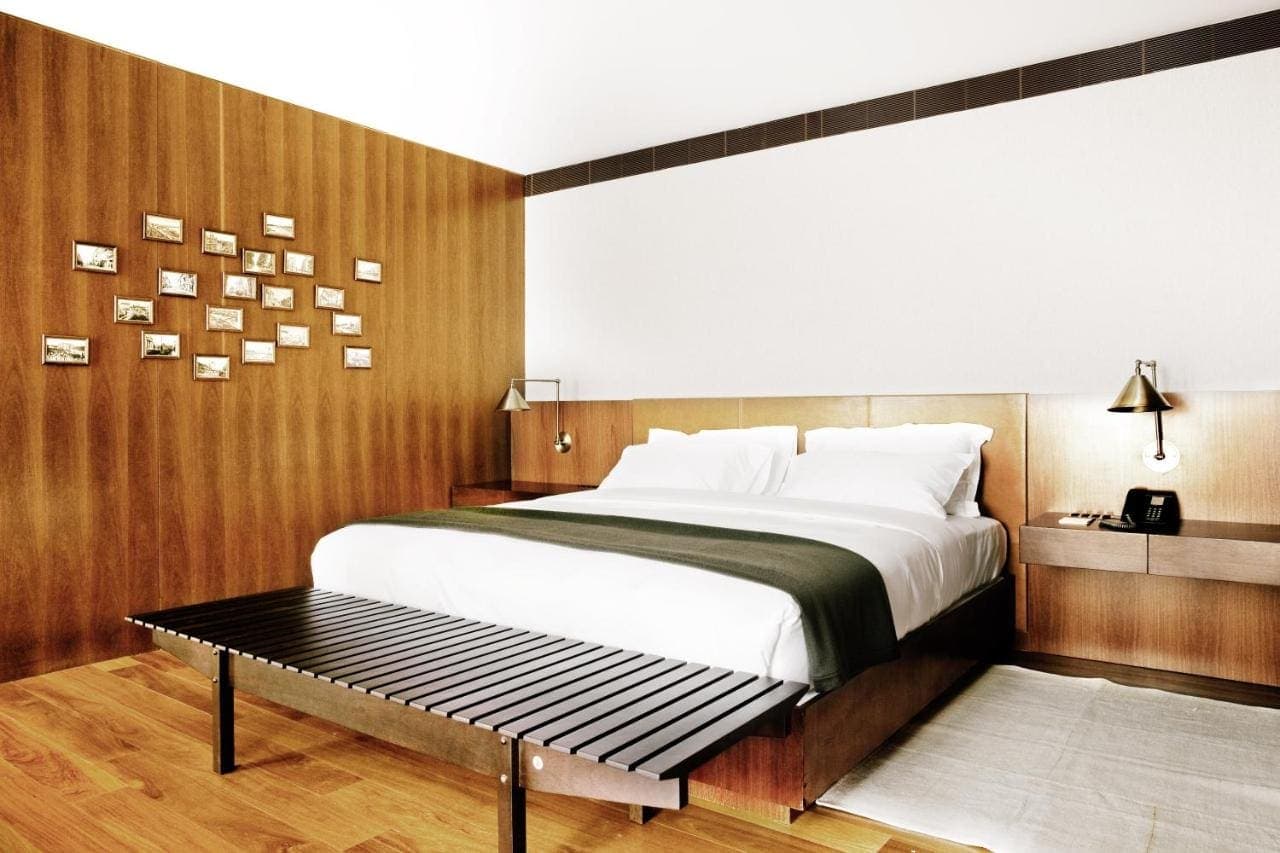 A room with a long bench at the foot of the bed