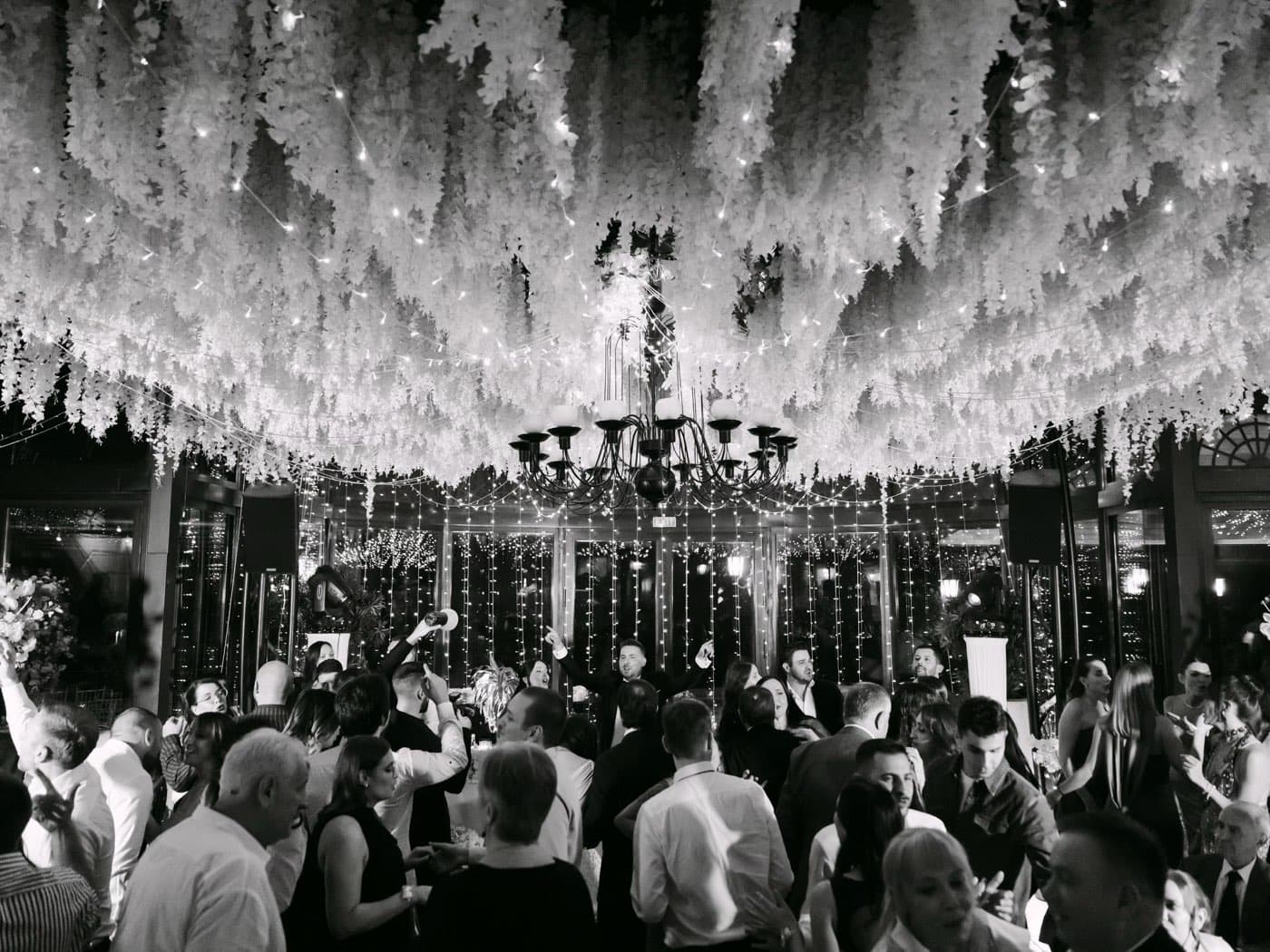 The dance floor under a ceiling of white blossoms and fairy lights
