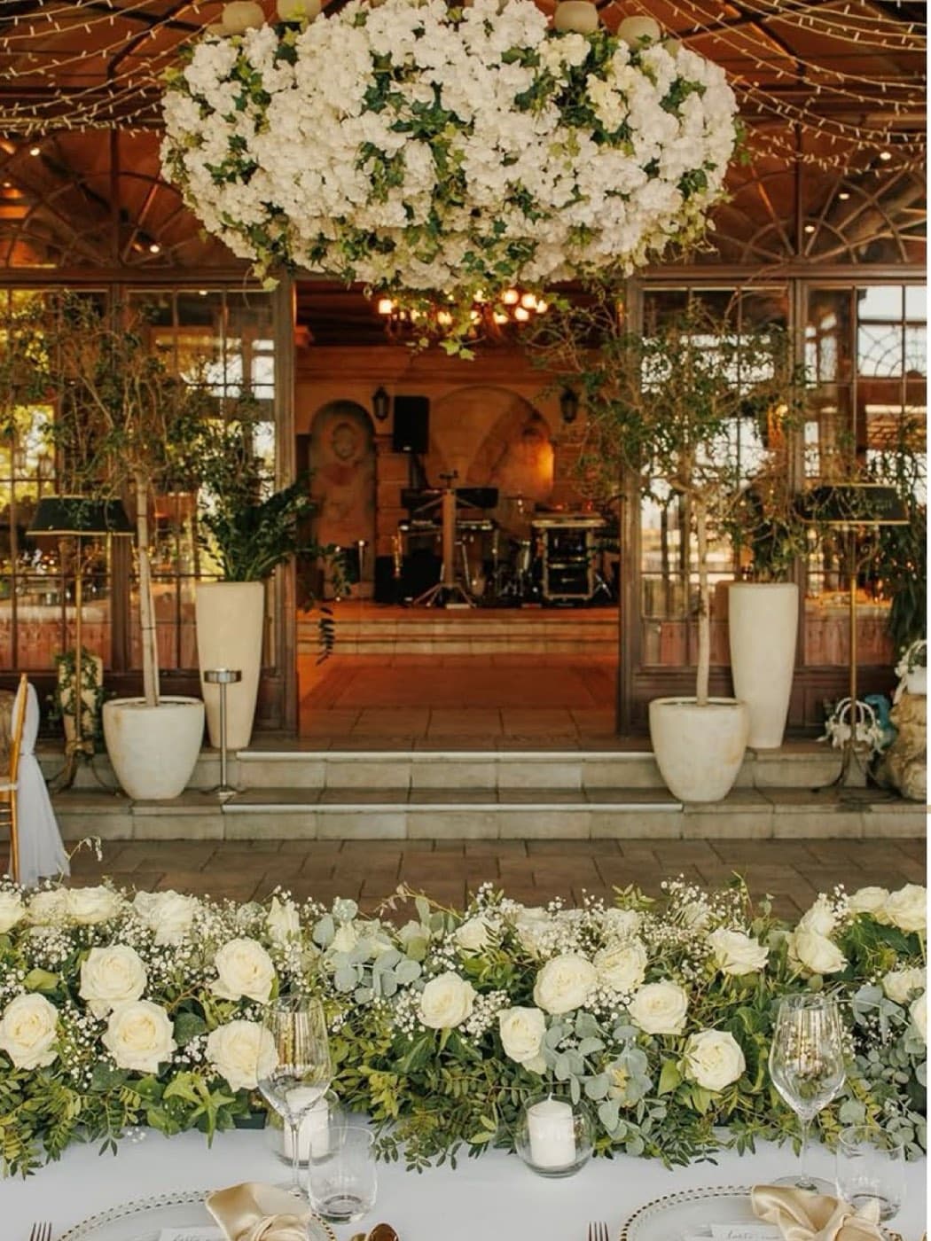 A floral chandelier above the head table, looking toward the stage